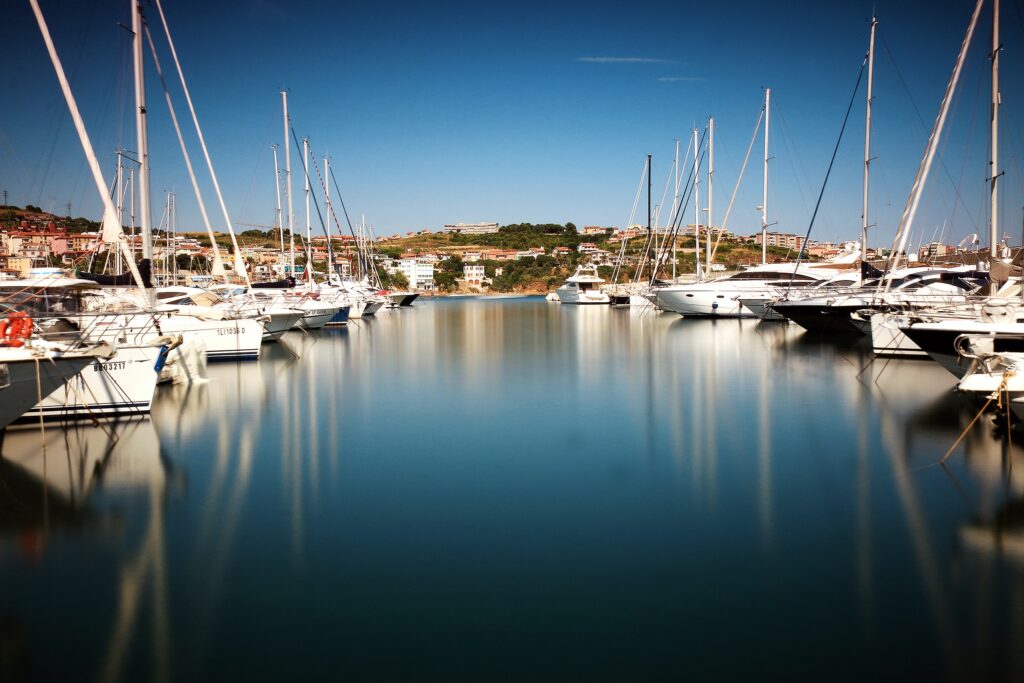 A group of boats in the water at a marina.